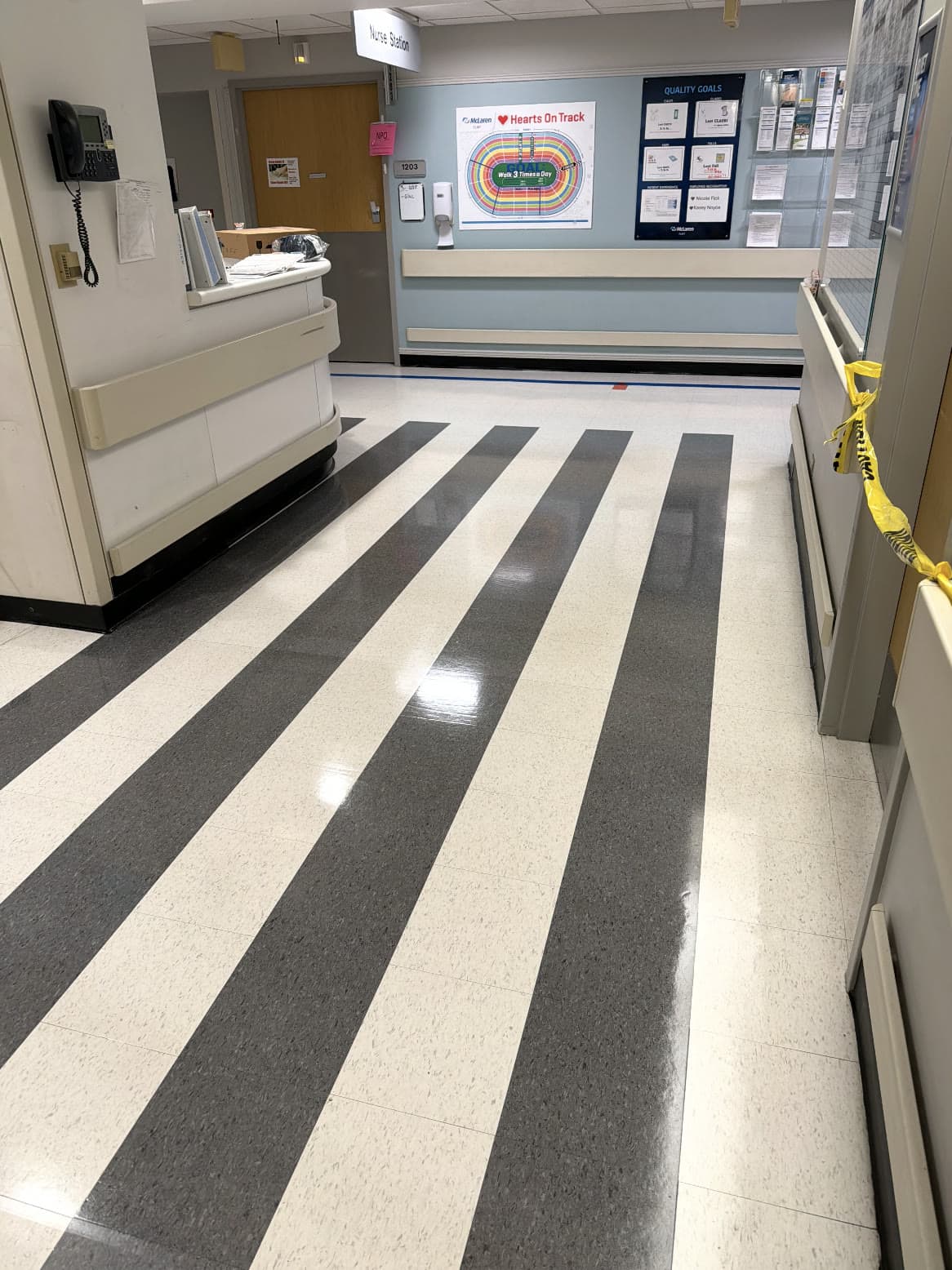 A hospital ward corridor with striped vinyl tile refinished to a high gloss.
