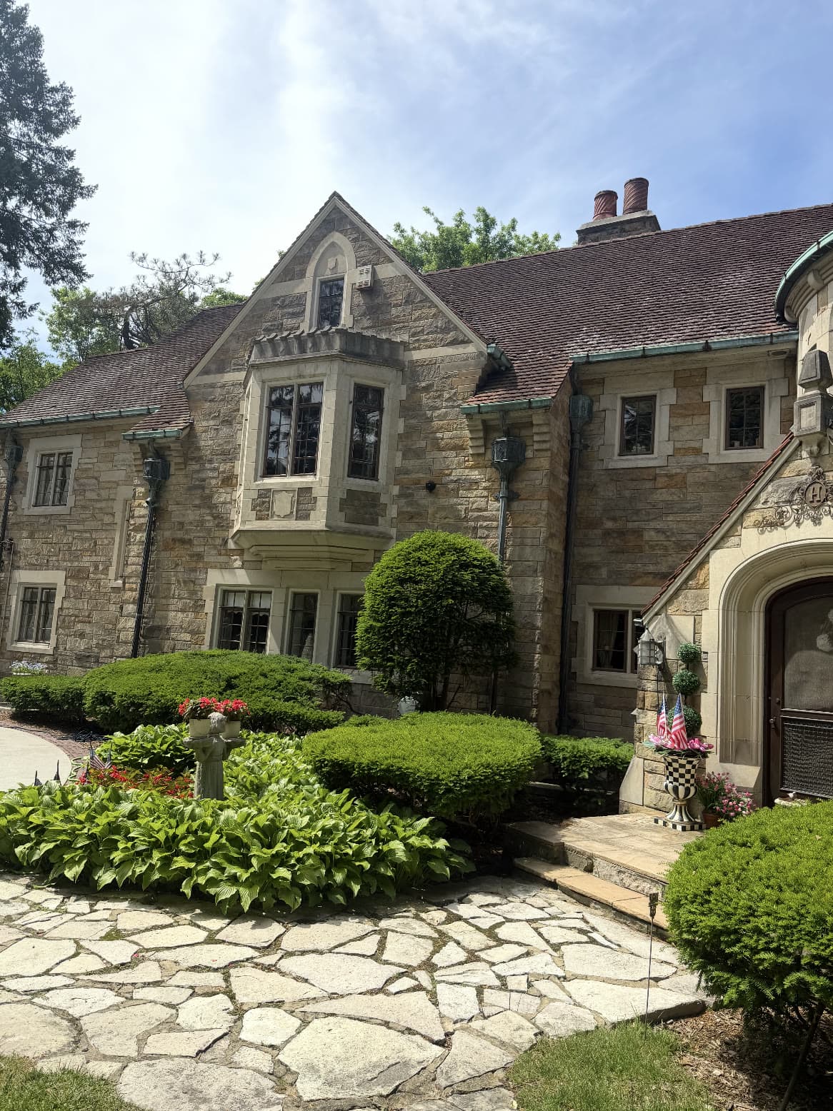 A stone residence with clean windows and maintained grounds, serviced by G & J's.